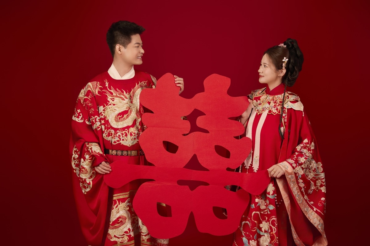 刘鑫与阚丽娜在喜庆红色棚景中合影